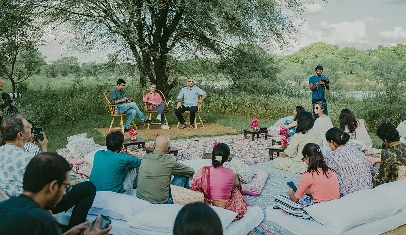 An open air dialogue under a tree at Dhun, the audience seated on floor cushions